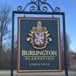 ANTIQUE COLONIAL-STYLE VENUE ENTRANCE SIGN, PRISMATIC INCISED AND GOLD-LEAF LETTERS, GOLD LEAF CARVED FAMILY CREST, WROUGHT IRON BRACKET WITH PVC PYLON, CHARLES CITY, VA