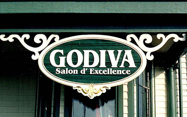 GODIVA SALON- CHESTERFIELD, VA 4’ X 6’ REDWOOD SANDBLASTED SIGN FACE WITH HAND CARVED & GOLD-LEAFED BASSWOOD SCROLLS MOUNTED ON HISTORIC VICTORIAN BUILDING